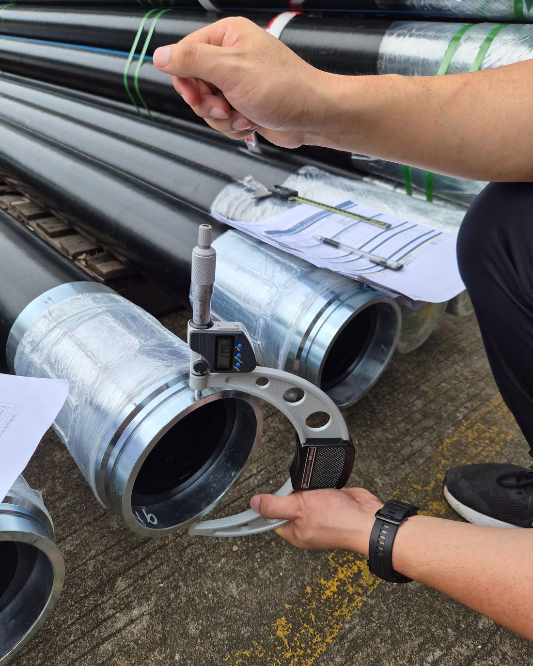 OctoPipe QA inspector measuring pipe outside diameter with calibrated calipers at the point of manufacture